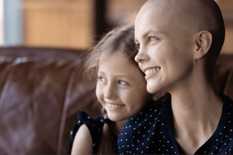 A young cancer patient's mother is embracing her daughter in a hug